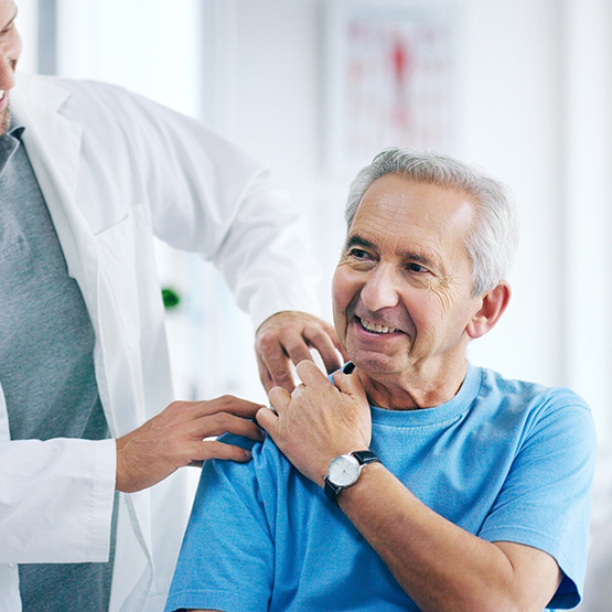Arzt untersucht die Schulter eines Patienten